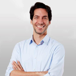 man with black hair smiling at camera