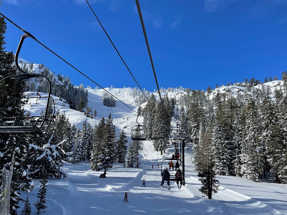 Snowy scenery with several people sitting on the ski lift