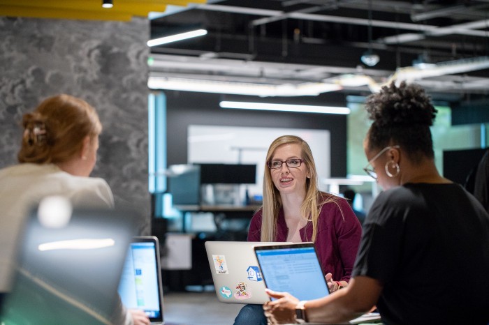 Three women working with their laptops in an office