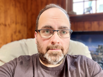 Man with glasses and beard looking at camera