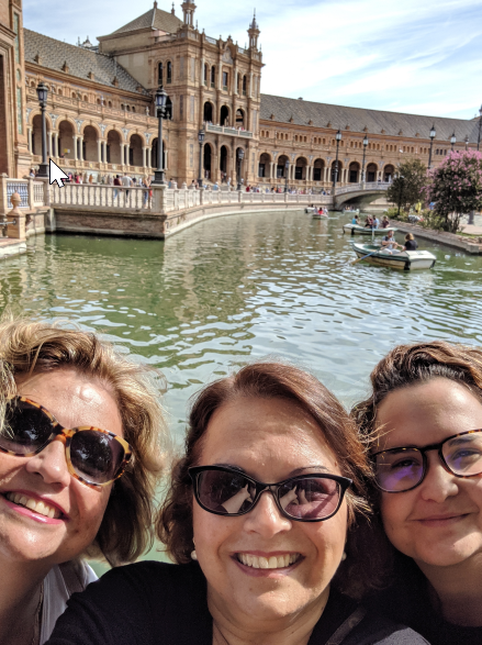 three women wearing sunglasses smiling at the camera in Spain